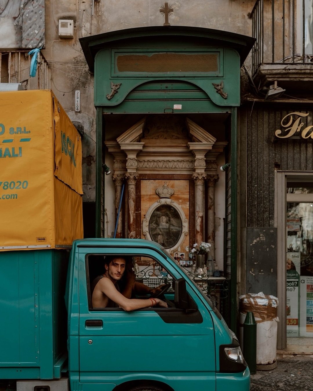 Laundry hangs from balconies, streets and stalls are festooned with the colours and cut-outs of the football team, buckets on ropes transport goods up several storeys, a Vespa zips past you with a hairdryer exhaust, Ape trucks weave between crowds, w